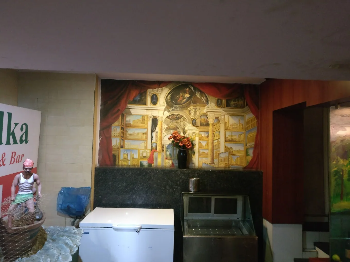 Live seafood display counter beneath a fisherman mural