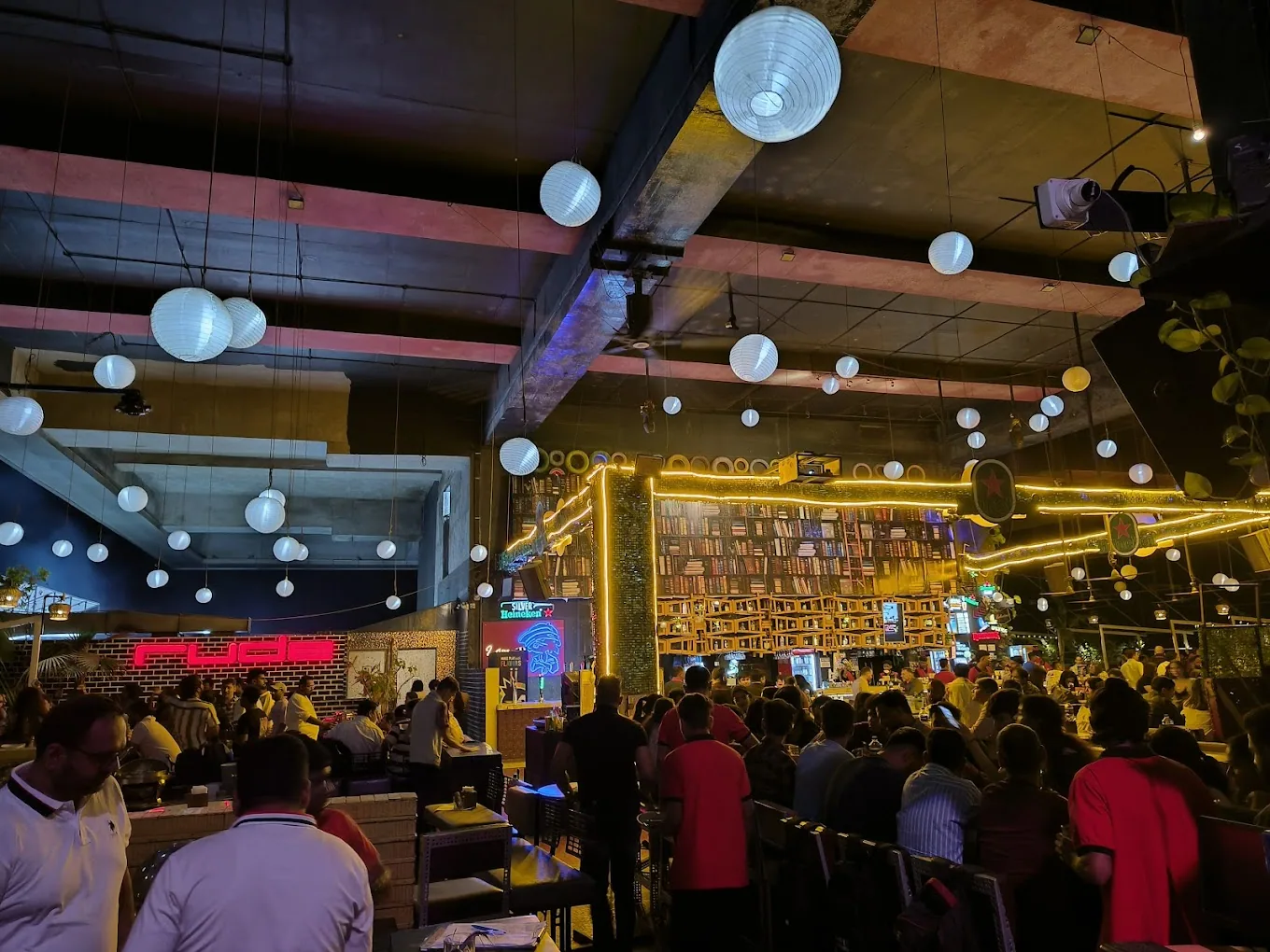 A packed room beneath paper lanterns
